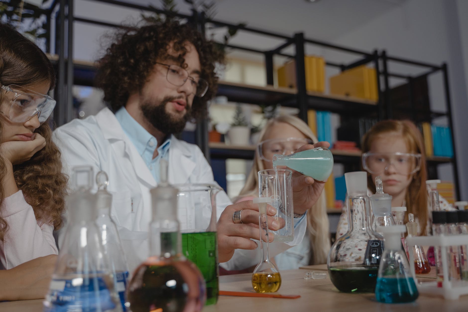 man in white dress shirt pouring wine on clear glass pitcher